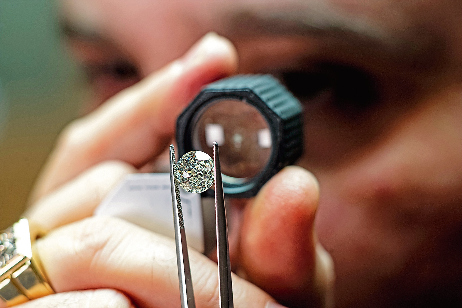 A polished natural diamond is examined through a loupe. A polished natural diamond is examined through a loupe.