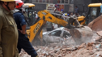 A JCB excavator removes debris from the site after a building collapsed near Satya Niketan at South-West Delhi, in New Delhi on Sunday. Rescue operations underway. (ANI) A JCB excavator removes debris from the site after a building collapsed near Satya Niketan at South-West Delhi, in New Delhi on Sunday. Rescue operations underway. (ANI)
