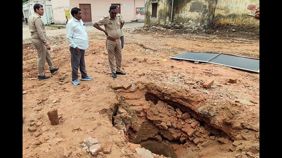 Police personnel and administrative officials inspecting the structural openings of an ancient brick-lined well uncovered during excavation and debris clearing operations at the Collectorate complex, in Saharanpur on Sunday. (ANI Video Grab)