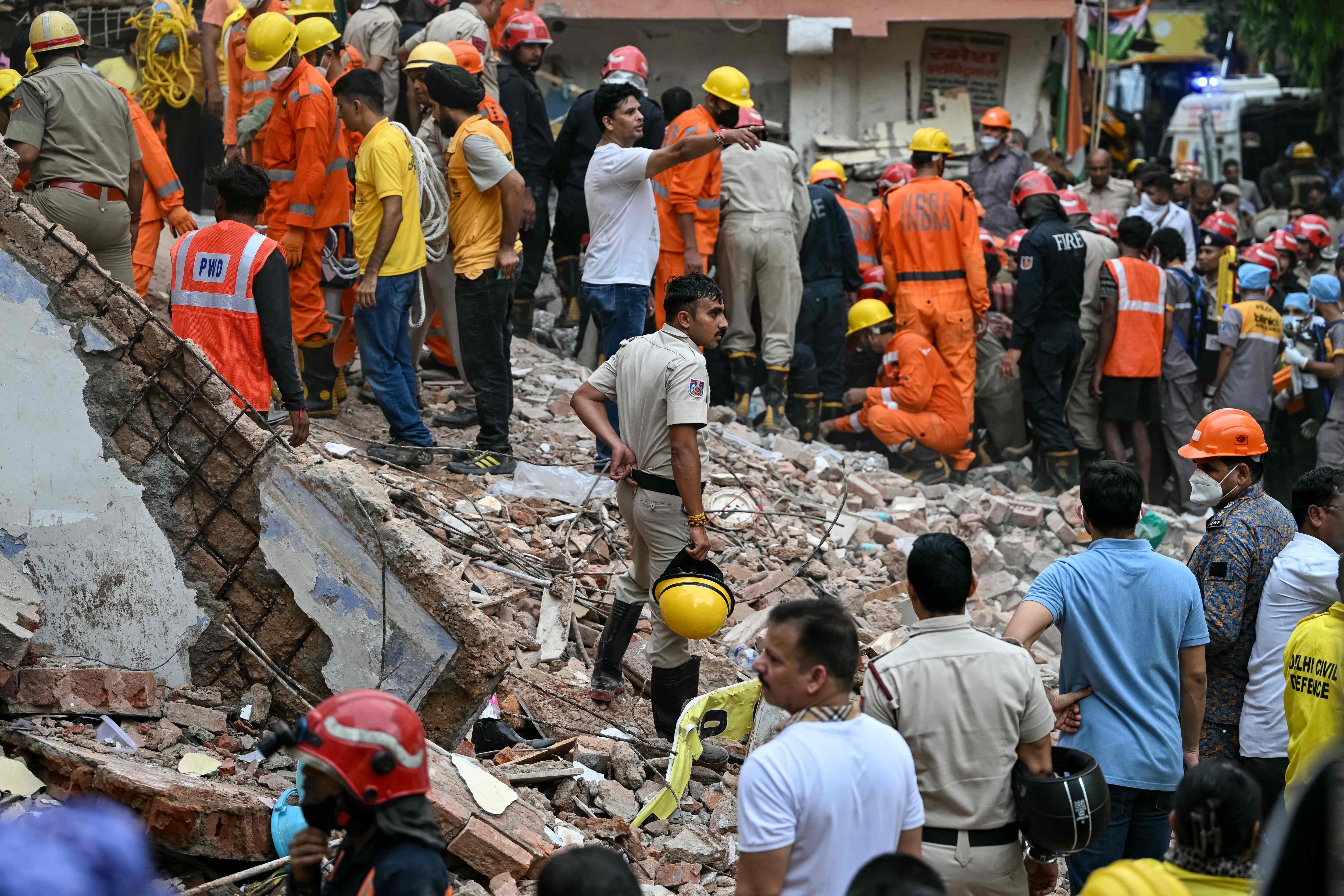 Rescue personnel conduct a search operation in the Satya Niketan area in New Delhi. (AFP) Rescue personnel conduct a search operation in the Satya Niketan area in New Delhi. (AFP)