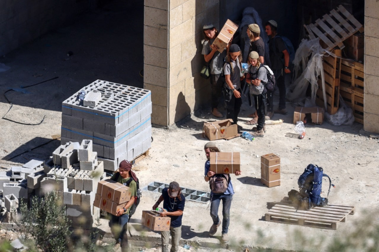 Israeli settlers taking building materials last month from a Palestinian-owned home under construction in the Israeli-occupied West Bank.