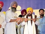 Punjab chief minister Bhagwant Mann with gangster-turned-politician Gurpreet Singh Sekhon after his induction into the AAP in Ferozepur on Sunday. (HT)