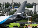 Miami-Dade Fire Rescue vehicles stand next to a Prime Air cargo plane at Miami International Airport after it overran the runway.