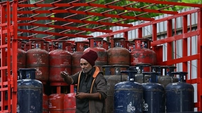 A delivery worker stands atop a truck carrying LPG cylinders at a HP Gas distribution point in Bengaluru. (AFP/Representational) A delivery worker stands atop a truck carrying LPG cylinders at a HP Gas distribution point in Bengaluru. (AFP/Representational)