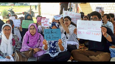 Intern doctors hold placards as they observe a hunger strike demanding an increase in their monthly internship stipend, in Srinagar, on Monday. (PTI)