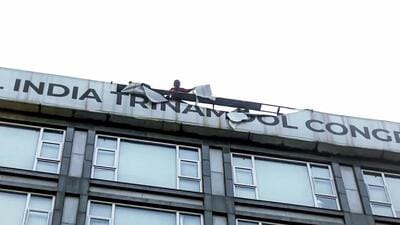 Kolkata Municipal Corporation personnel remove the signboard that reads 'All India Trinamool Congress' from a building on Camac Street that houses TMC MP Abhishek Banerjee's Office, on August 27 (ANI Video Grab)