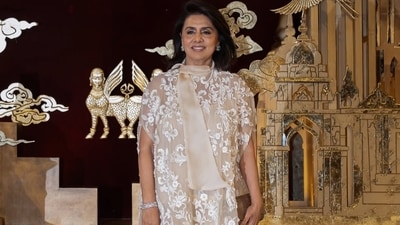 Neetu Kapoor wore a white and beige embroidered suit paired with diamond and emerald studs, glittering pumps, and a brown crocodile-skin clutch. (abujanisandeepkhosla/Instagram) Neetu Kapoor wore a white and beige embroidered suit paired with diamond and emerald studs, glittering pumps, and a brown crocodile-skin clutch. (abujanisandeepkhosla/Instagram)