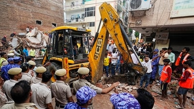 NDRF, fire department officials during a rescue operation after a 50-year-old five-storey building housing a boys' hostel collapsed in a congested bylane in Satya Niketan. (PTI)