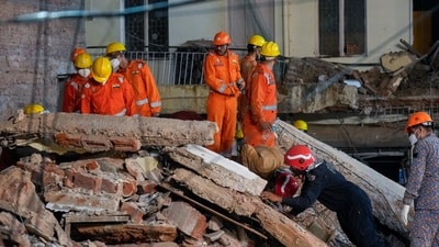 NDRF, fire department officials during a rescue operation after a 50-year-old five-storey building housing a boys' hostel collapsed in a congested bylane in Satya Niketan. (PTI) NDRF, fire department officials during a rescue operation after a 50-year-old five-storey building housing a boys' hostel collapsed in a congested bylane in Satya Niketan. (PTI)