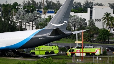 Miami-Dade Fire Rescue vehicles stand next to a Prime Air cargo plane at Miami International Airport after it overran the runway. ((Photo by CHANDAN KHANNA / AFP))
