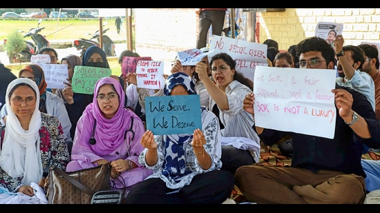 Intern doctors hold placards as they observe a hunger strike demanding an increase in their monthly internship stipend, in Srinagar, on Monday. (PTI)