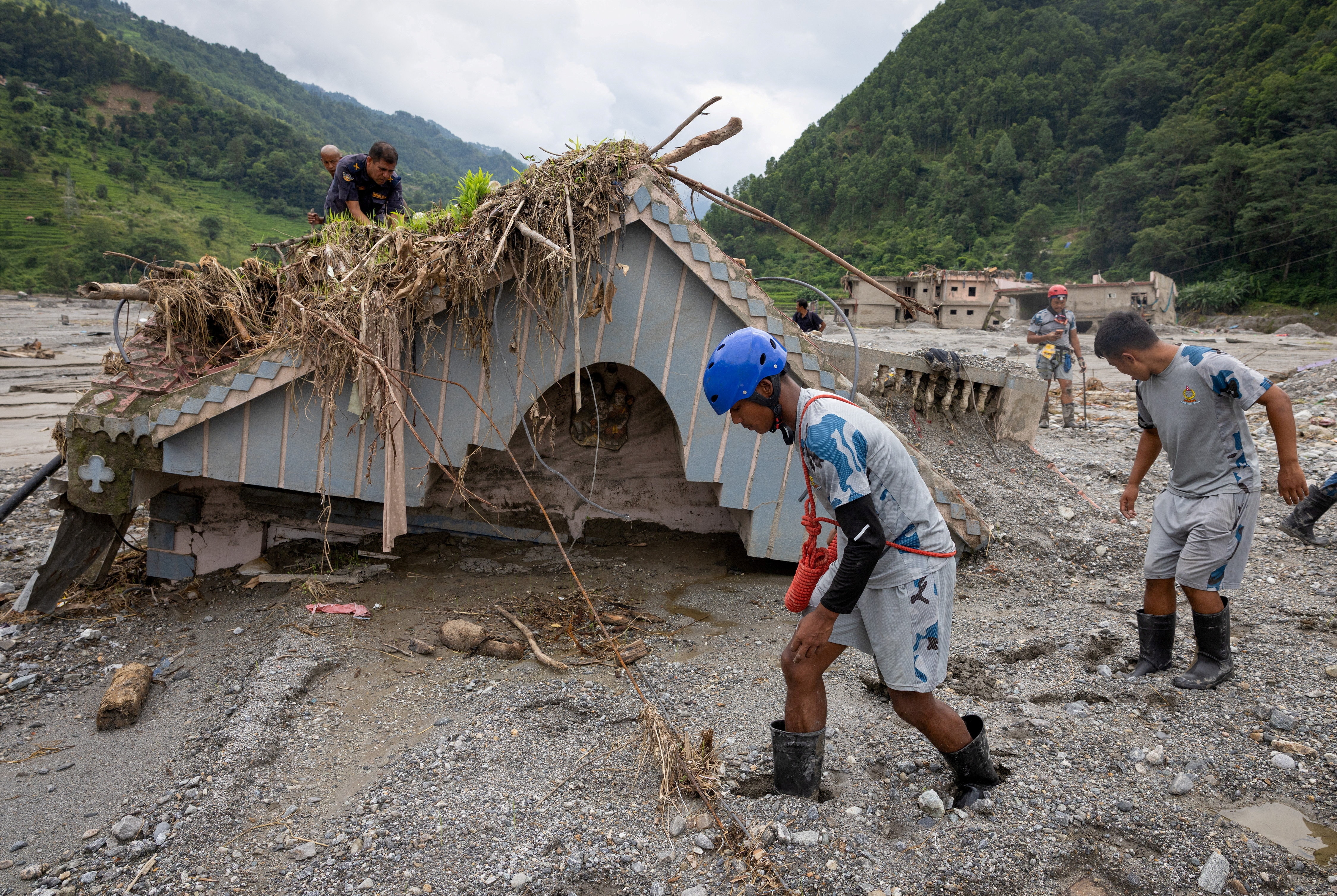 Nepal Police and Armed Police Force (APF) members search the house of Chandika Kumari Shrestha, who was rescued alive on Saturday, for more survivors and victims of the deadly flash floods and mudslides, in Betrawati, Nuwakot district, Nepal. (REUTERS)