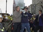 (FILES) US President George W. Bush (L) speaks through a megaphone beside retired firefighter Bob Beckwith, 69, to firemen and other workers on September 14, 2001 at the site of the destroyed World Trade Center. September 11, 2026, will mark the 25th anniversary of the September 11, 2001, attacks that killed nearly 3,000 people in New York, Washington and Pennsylvania.