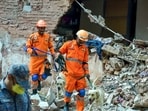 NDRF personnel with a K9 dog squad conduct a search and rescue operation at the PG building collapse site at Satya Niketan, in New Delhi. 