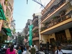 A view of residential buildings and paying guest (PG) accommodations in the Satya Niketan area, where electric meters, wiring and other utility installations are seen exposed.