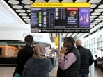 Travellers check on a departure board displaying cancelled flights at Heathrow Airport Terminal 4, in Greater London, Britain.