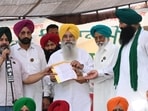 Punjab agriculture minister Gurmeet Singh Khudian hands over an assurance letter to farmer leaders at their protest site in Mohali on Monday. (Ravi Kumar/HT)