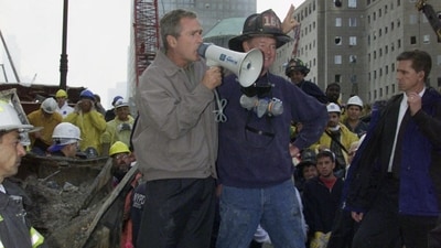 (FILES) US President George W. Bush (L) speaks through a megaphone beside retired firefighter Bob Beckwith, 69, to firemen and other workers on September 14, 2001 at the site of the destroyed World Trade Center. September 11, 2026, will mark the 25th anniversary of the September 11, 2001, attacks that killed nearly 3,000 people in New York, Washington and Pennsylvania. ((Photo by Paul J. RICHARDS / AFP)) (FILES) US President George W. Bush (L) speaks through a megaphone beside retired firefighter Bob Beckwith, 69, to firemen and other workers on September 14, 2001 at the site of the destroyed World Trade Center. September 11, 2026, will mark the 25th anniversary of the September 11, 2001, attacks that killed nearly 3,000 people in New York, Washington and Pennsylvania. ((Photo by Paul J. RICHARDS / AFP))