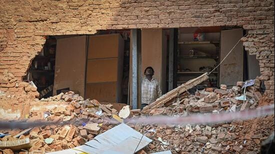 MCD personnel installing temporary structural supports in buildings adjacent to the Satya Niketan collapse site. (Sanchit Khanna/HT Photo)