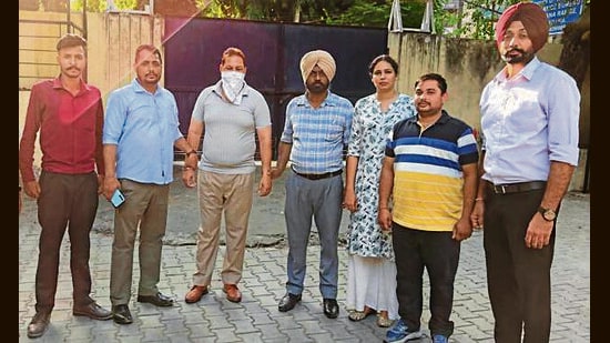 The ASI (third from left) in the custody of vigilance bureau officials. (HT Photo)