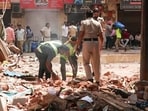 Delhi building collapse LIVE: Workers clear the debris in the presence of security personnel at the site of the Satya Niketan building collapse (6th Sep), in New Delhi on Tuesday. 