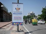 Traffic moves along a street past a hoarding, displayed ahead of the BRICS summit in New Delhi on September 9, 2026. (Photo by Sajjad HUSSAIN / AFP)