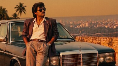 An AI-generated 1980s-style photograph featuring a man posing beside a classic car. (Gemini)