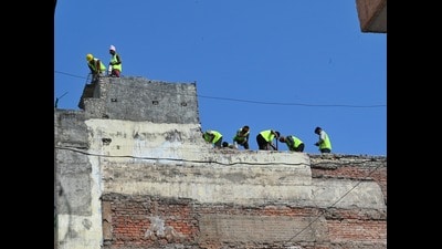 Municipal Corporation of Delhi (MCD) workers demolish a building declared “dangerous” adjacent to the collapsed paying guest (PG) accommodation at Satya Niketan, in New Delhi on Thursday. (Vipin Kumar/Hindustan Times)