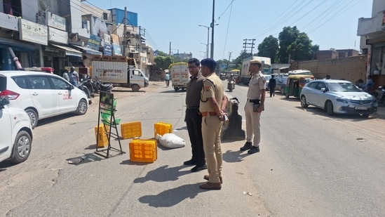 Police personnel at the site where the 40-year-old contractor was killed on Gurugram's Bassi Road. (HT Photo/ Parveen Kumar)