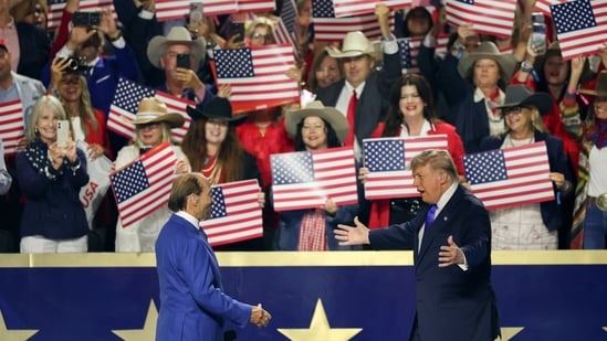Singer Lee Greenwood, left, greets US President Donald Trump during the first day of the Republican Midterm Convention at the American Airlines Center in Dallas, Texas.