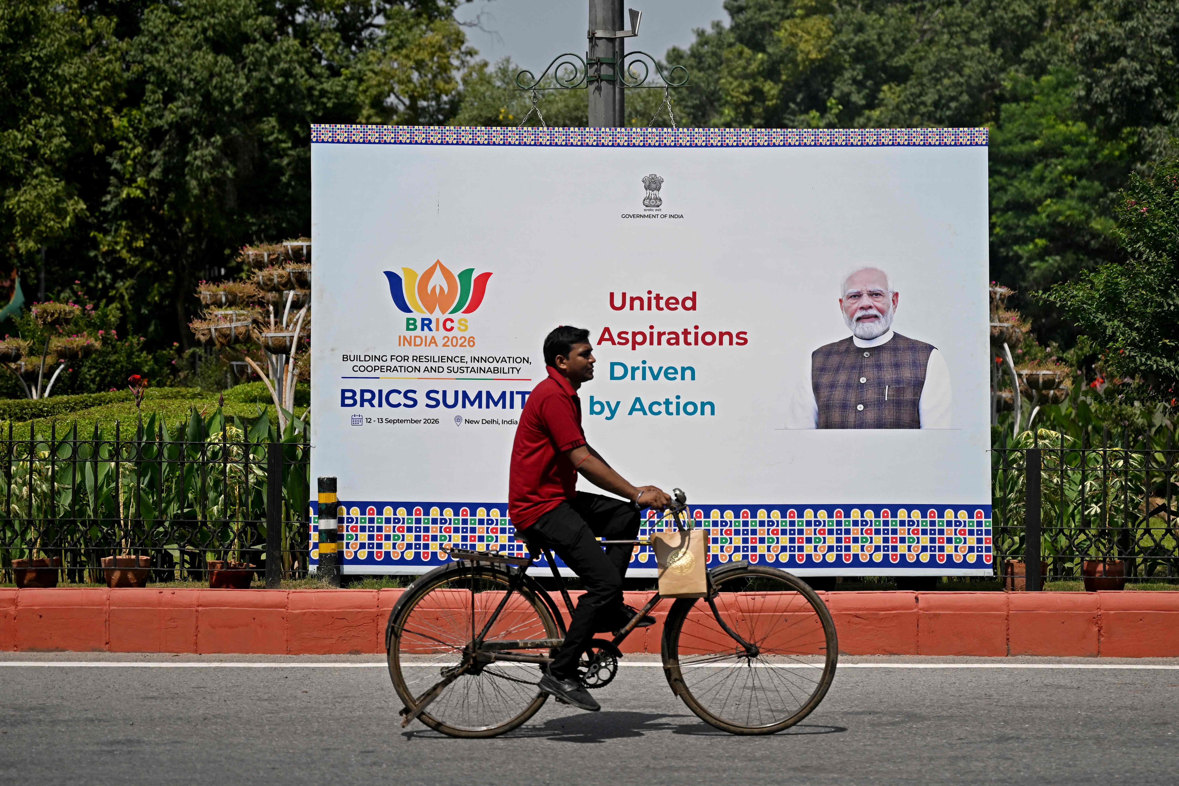 A cyclist rides past a hoarding featuring India's Prime Minister Narendra Modi, displayed ahead of the BRICS summit in New Delhi on September 9, 2026. (AFP) A cyclist rides past a hoarding featuring India's Prime Minister Narendra Modi, displayed ahead of the BRICS summit in New Delhi on September 9, 2026. (AFP)