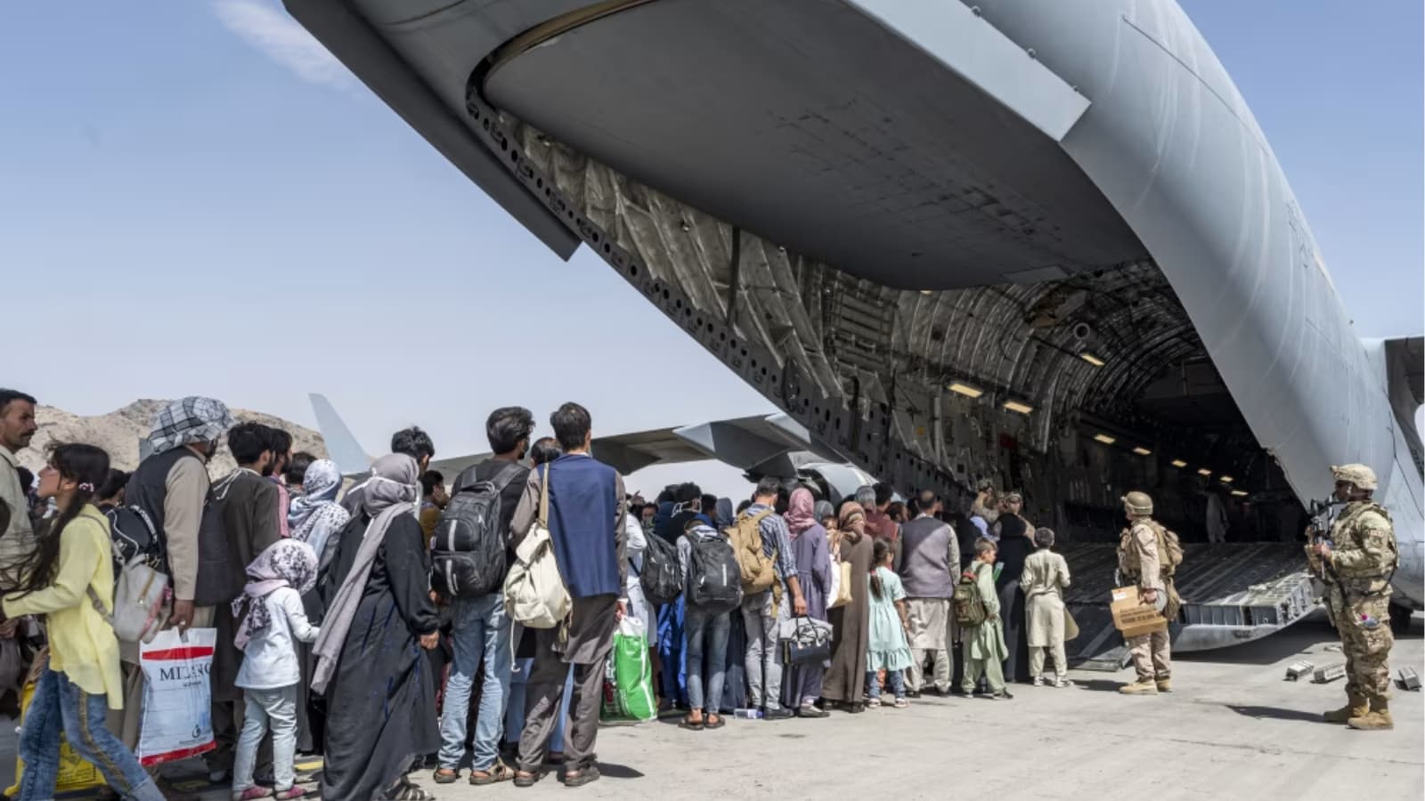US airmen and Marines guide evacuees aboard a US Air Force C-17 Globemaster III in support of the Afghanistan evacuation in 2021 (US Air Force via AP)