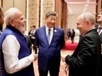Prime Minister Narendra Modi shares a moment with Russian President Vladimir Putin as Chinese President Xi Jinping looks on during day two of the BRICS Summit in New Delhi.(REUTERS)