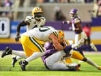 Minnesota Vikings quarterback Kyler Murray, center, is tackled by Green Bay Packers' Lukas van Ness, left, and Javon Bullard, right, during the first half of an NFL football game in Minneapolis, Minn. (AP Photo/Abbie Parr)