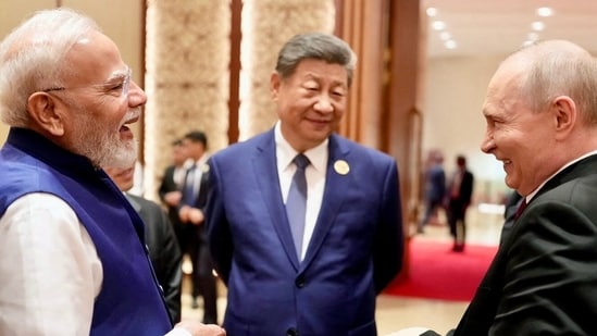 Prime Minister Narendra Modi shares a moment with Russian President Vladimir Putin as Chinese President Xi Jinping looks on during day two of the BRICS Summit in New Delhi.