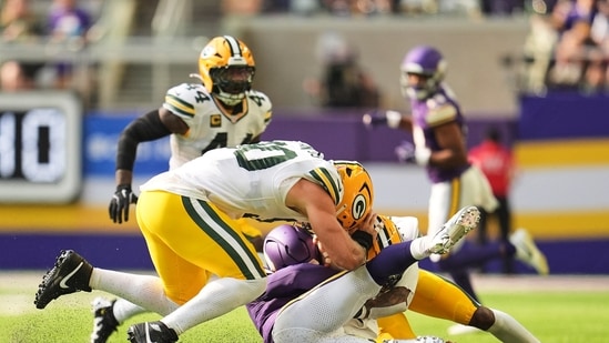 Minnesota Vikings quarterback Kyler Murray, center, is tackled by Green Bay Packers' Lukas van Ness, left, and Javon Bullard, right, during the first half of an NFL football game in Minneapolis, Minn. (AP Photo/Abbie Parr)