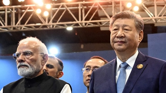  Prime Minister Narendra Modi (L) stands alongside China's President Xi Jinping during the 18th BRICS Summit in New Delhi.