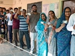 Voters stand in a queue and show their voter ID cards during the Municipal Corporation elections at a polling station, in Jaipur on Friday.

