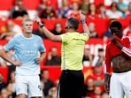 Erling Haaland reacts as referee Michael Oliver awards their first goal following a VAR review.