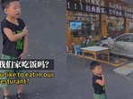Little boy serving customers at a restaurant in China.