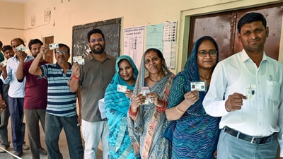 Voters stand in a queue and show their voter ID cards during the Municipal Corporation elections at a polling station, in Jaipur on Friday. (Ashok Sharma) Voters stand in a queue and show their voter ID cards during the Municipal Corporation elections at a polling station, in Jaipur on Friday. (Ashok Sharma)