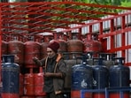 A delivery worker stands atop a truck carrying LPG cylinders at a HP Gas distribution point in Bengaluru.