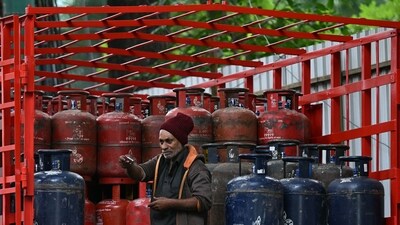A delivery worker stands atop a truck carrying LPG cylinders at a HP Gas distribution point in Bengaluru. (AFP) A delivery worker stands atop a truck carrying LPG cylinders at a HP Gas distribution point in Bengaluru. (AFP)
