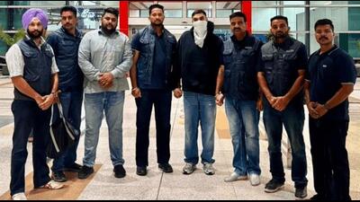 Punjab Police’s Anti-Gangster Task Force (AGTF) members after arresting Karamveer Singh (face covered), an accomplice of jailed gangster Lawrence Bishnoi, at New Delhi’s Indira Gandhi International Airport following his deportation from Canada on Monday. (X) Punjab Police’s Anti-Gangster Task Force (AGTF) members after arresting Karamveer Singh (face covered), an accomplice of jailed gangster Lawrence Bishnoi, at New Delhi’s Indira Gandhi International Airport following his deportation from Canada on Monday. (X)