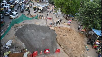 Workers are filling the cavity in layers with soil and substrate, compacting each layer to strengthen the road before laying bitumen. (PARVEEN KUMAR/HINDUSTAN TIMES)