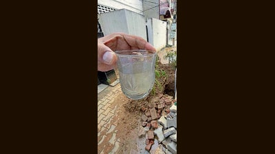 A resident shows a glass of contaminated water on Wednesday. (Gurpreet Singh/HT)