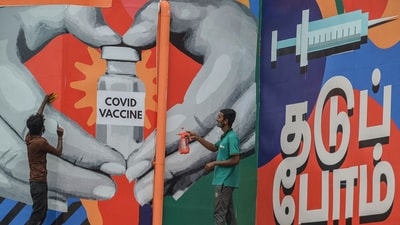 Workers give finishing touches to a huge mural made on the facade of the Tambaram railway station, to create awareness and promote Covid-19 coronavirus vaccination in Chennai on July 4, 2021. (Photo by Arun SANKAR / AFP) (AFP)