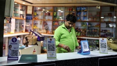 QR codes of digital payment firms PhonePe and Paytm are seen on the counter of a grocery store in Ahmedabad (REUTERS/File)