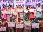 Delhi Chief Minister Rekha Gupta in a group photo with beneficiaries at the official letter distribution ceremony under Delhi Lakshmi Yojana.
