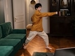 An adult person practising Tai Chi exercise indoors.
